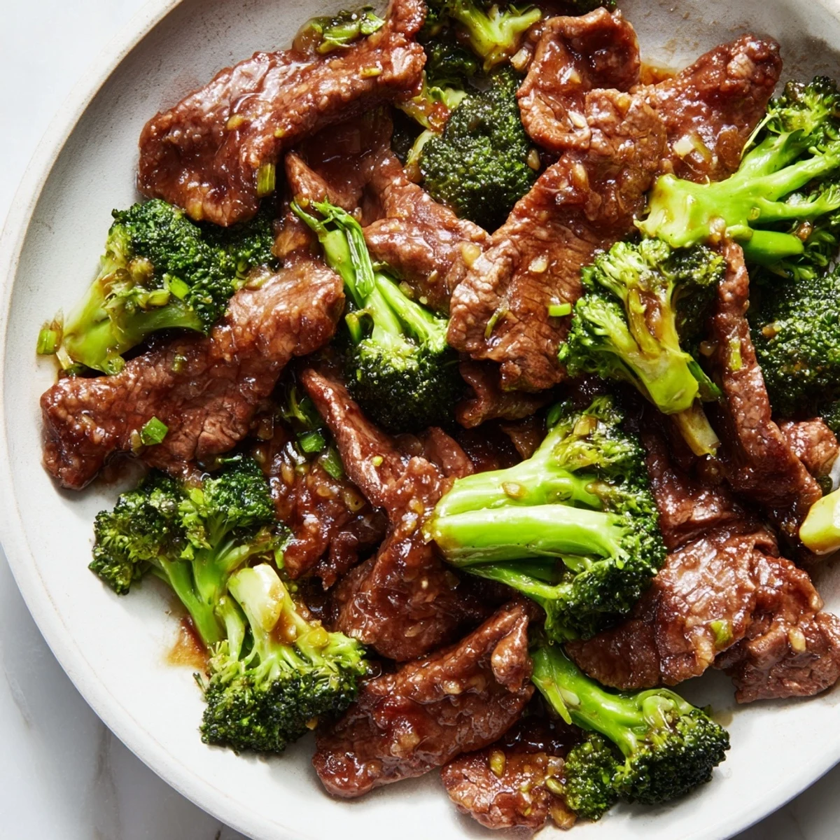 A close-up of sizzling Beef and Broccoli Stir Fry, showcasing juicy beef strips and vibrant green florets coated in savory oyster sauce.