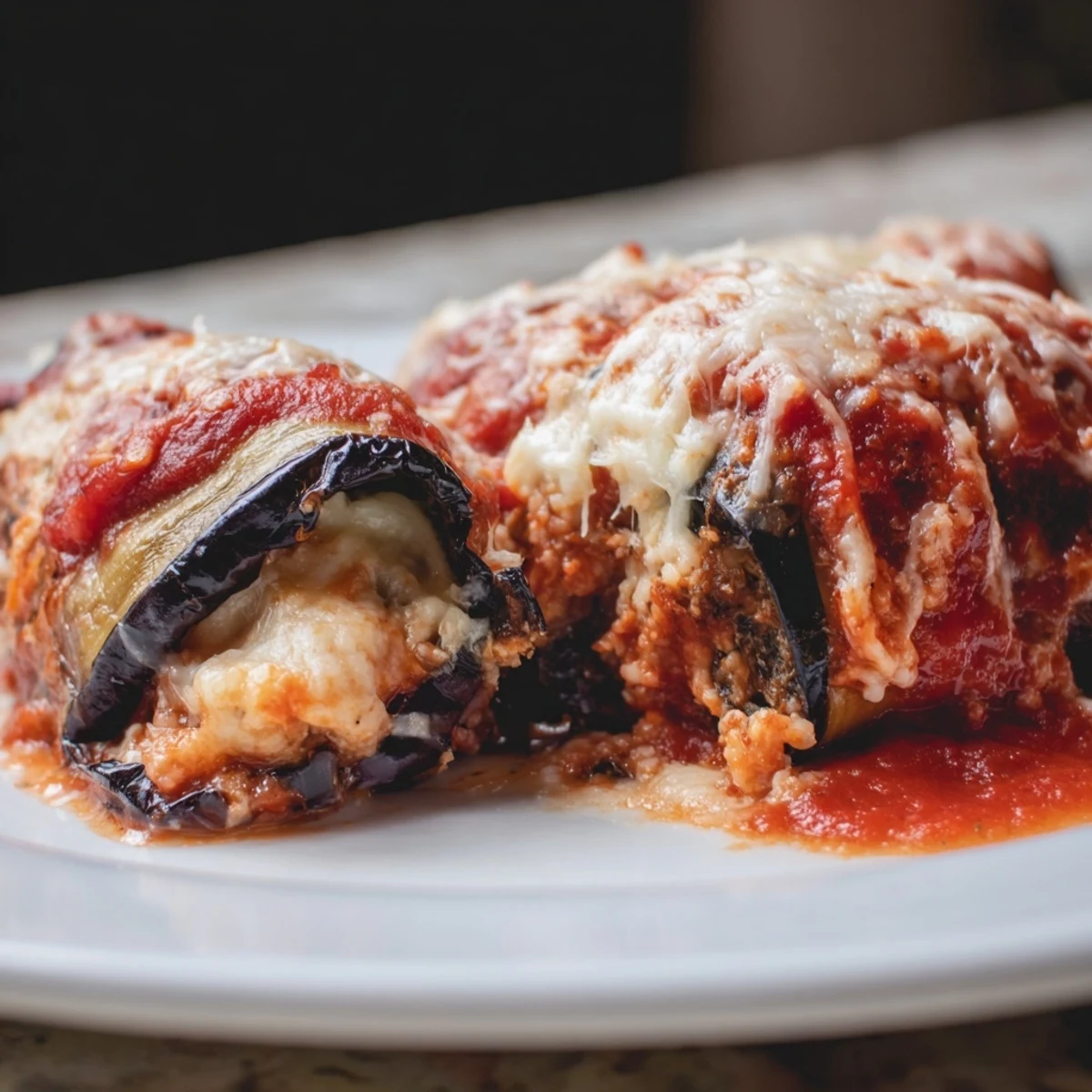 Tender Baked Eggplant Rollatini with Ricotta and Herbs on a plate, garnished with fresh parsley for a weeknight dinner.