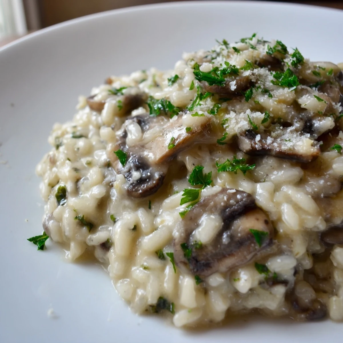 A steaming bowl of creamy mushroom risotto garnished with fresh parsley and a Parmesan swirl, perfect for a comforting Italian dinner.