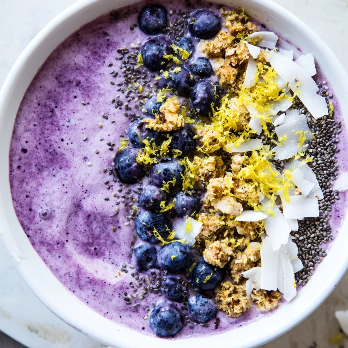 Creamy Lemon Blueberry Smoothie Bowl, garnished with chia seeds and lemon zest, served in a bowl for a nourishing snack.  