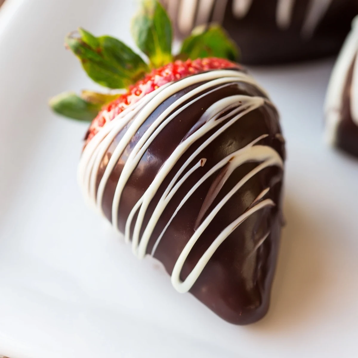Clean, fresh strawberries dipped in dark chocolate and finished with a zigzag white drizzle, ready to chill on a tray.
