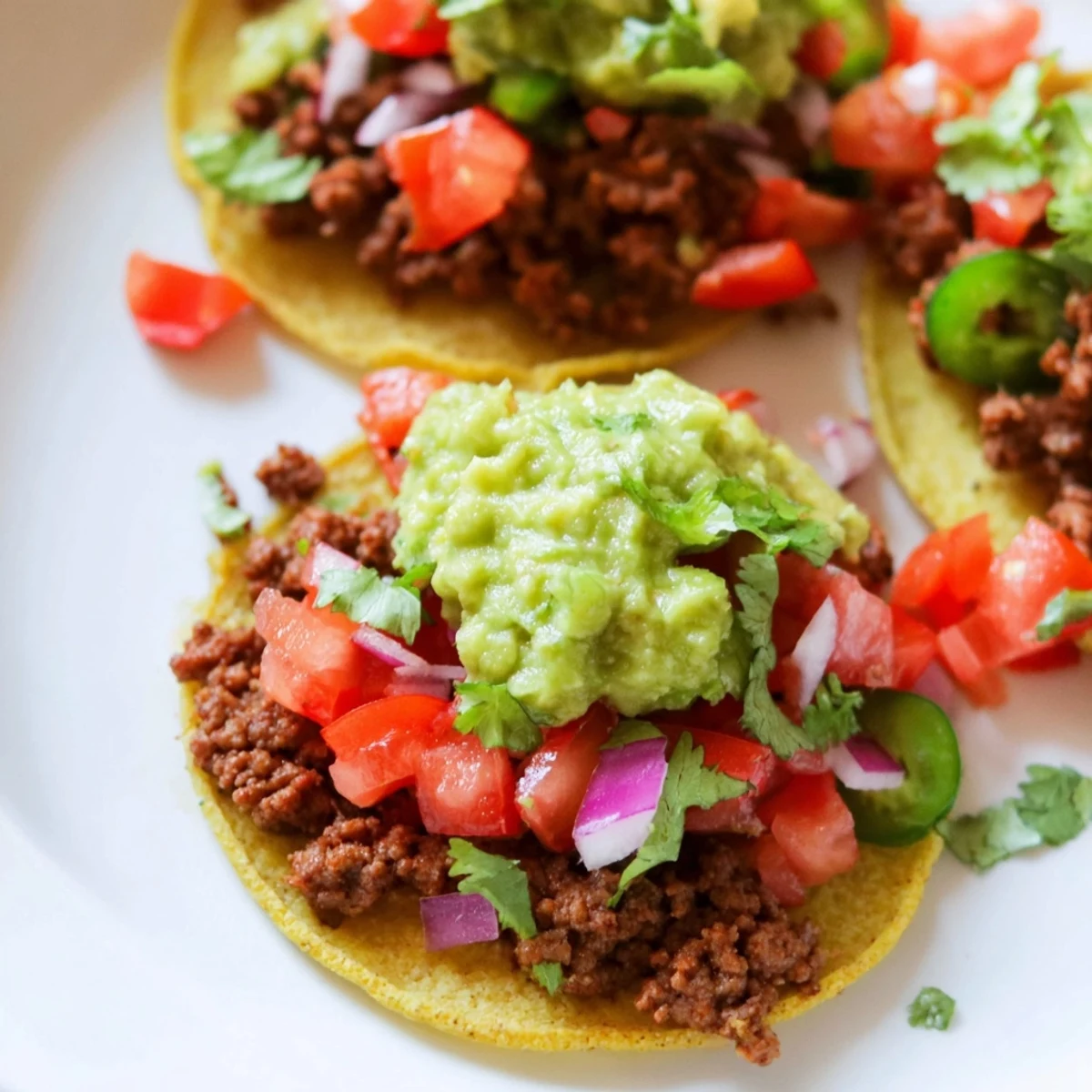 Appetizer platter of bite-sized Mexican tacos featuring savory meat, zesty lime, and crumbled queso fresco.