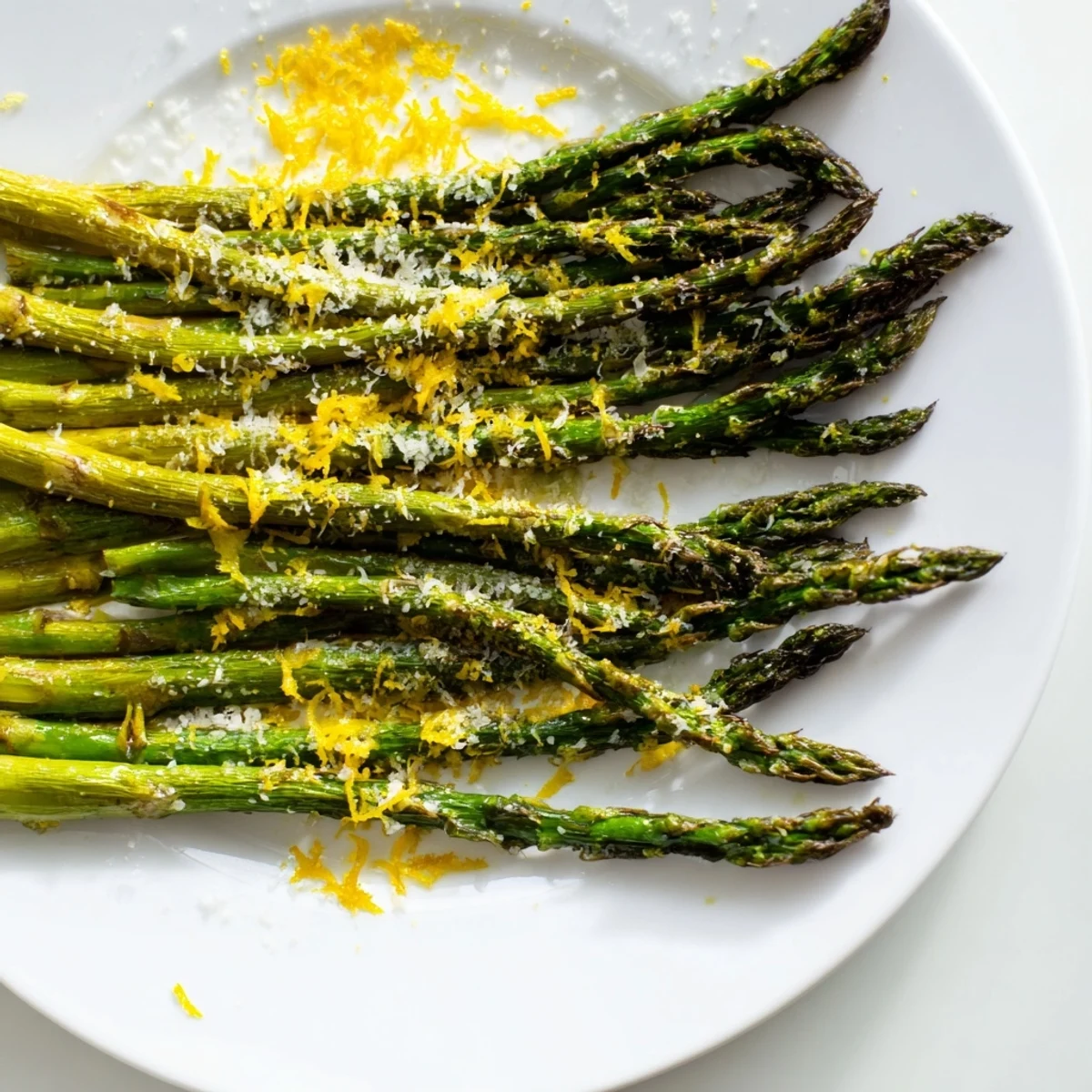 Freshly roasted Parmesan asparagus topped with lemon, glistening with olive oil on a rustic kitchen counter.  