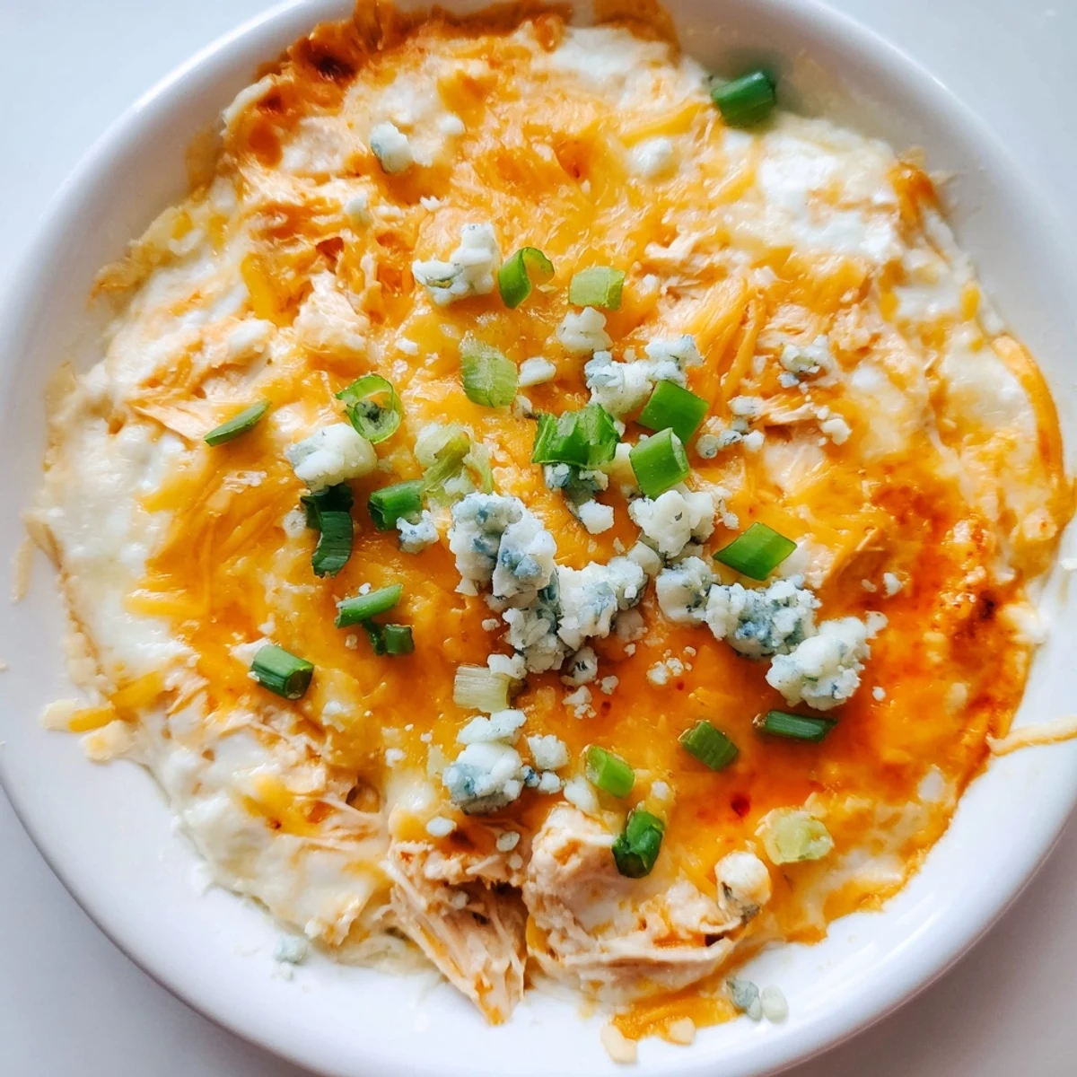 Golden-brown melted cheese topping highlights this delicious Keto Buffalo Chicken Dip, ready to serve with crisp celery sticks. 