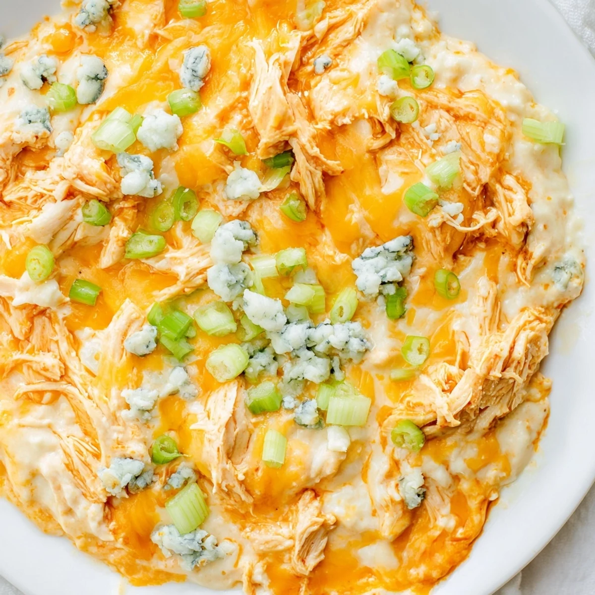 A low-carb appetizer dish of Keto Buffalo Chicken Dip with ranch and buffalo sauce flavors, garnished with fresh green onions.