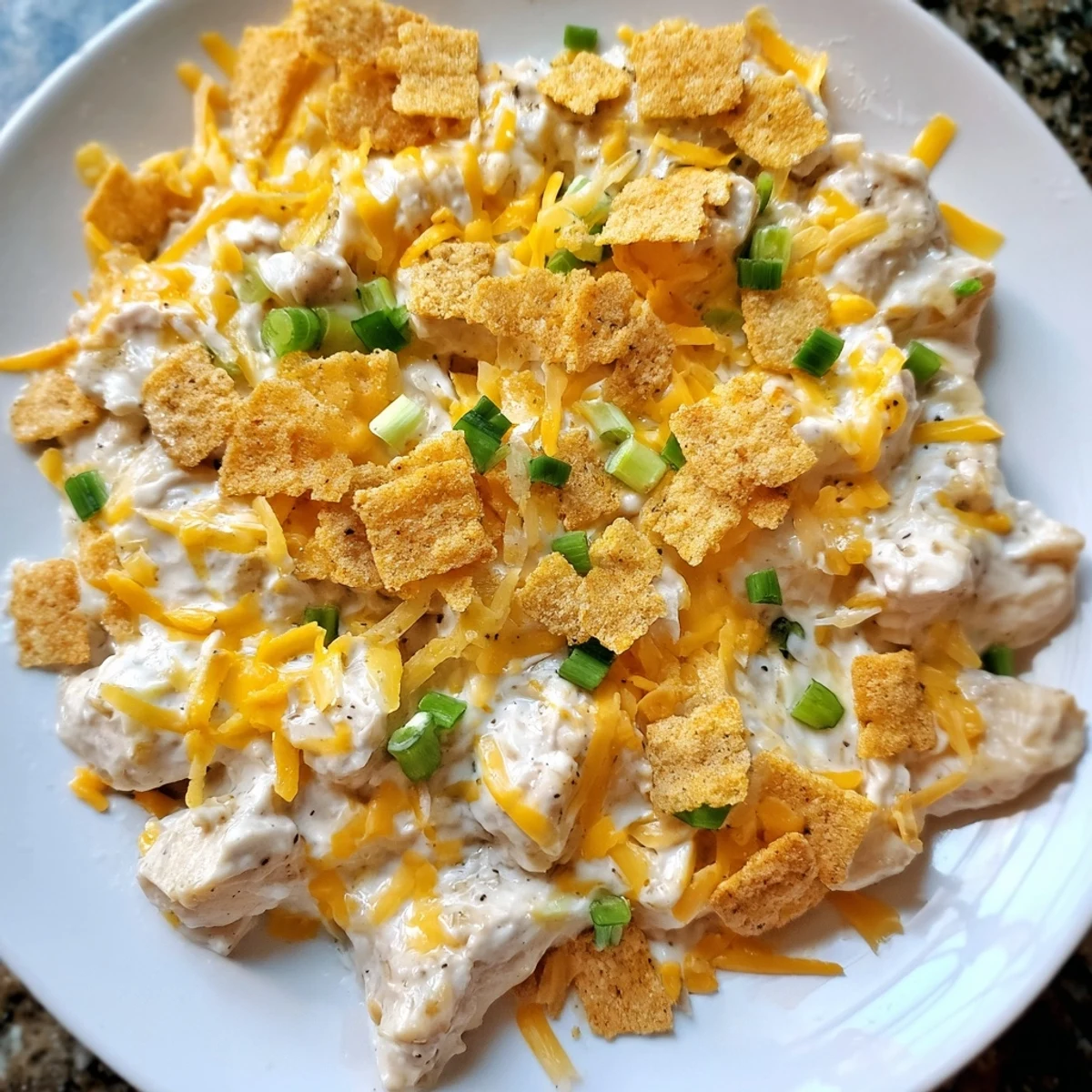 Golden brown Sour Cream and Onion Chicken breasts bubbling with creamy sauce in a baking dish, topped with melted cheddar.