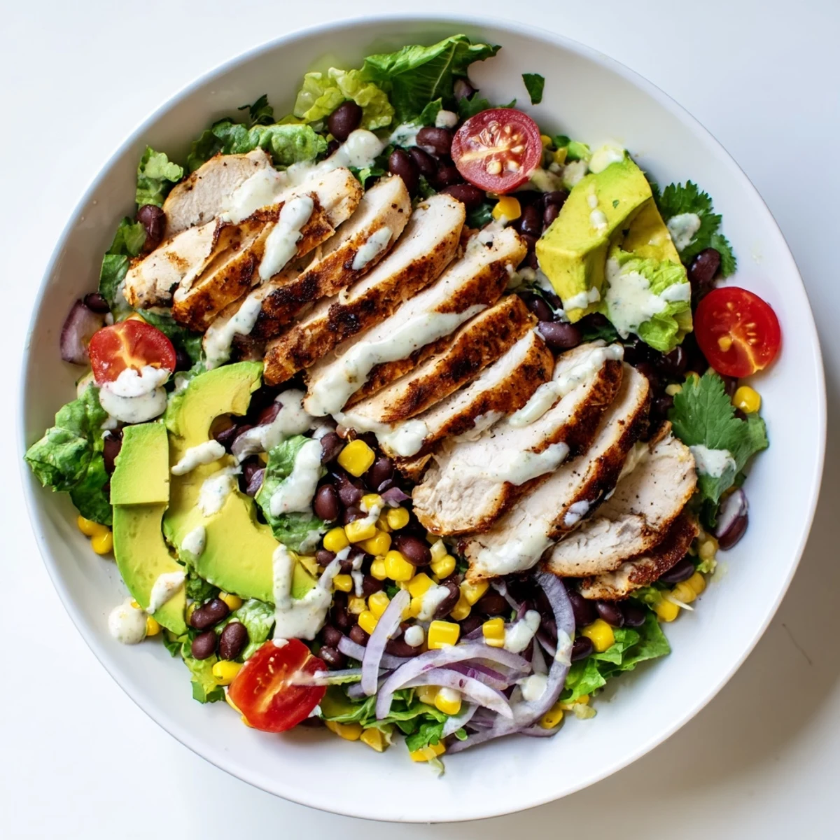 Hearty Chipotle Lime Chicken Salad featuring tender marinated chicken on fresh greens, topped with colorful veggies and cilantro.