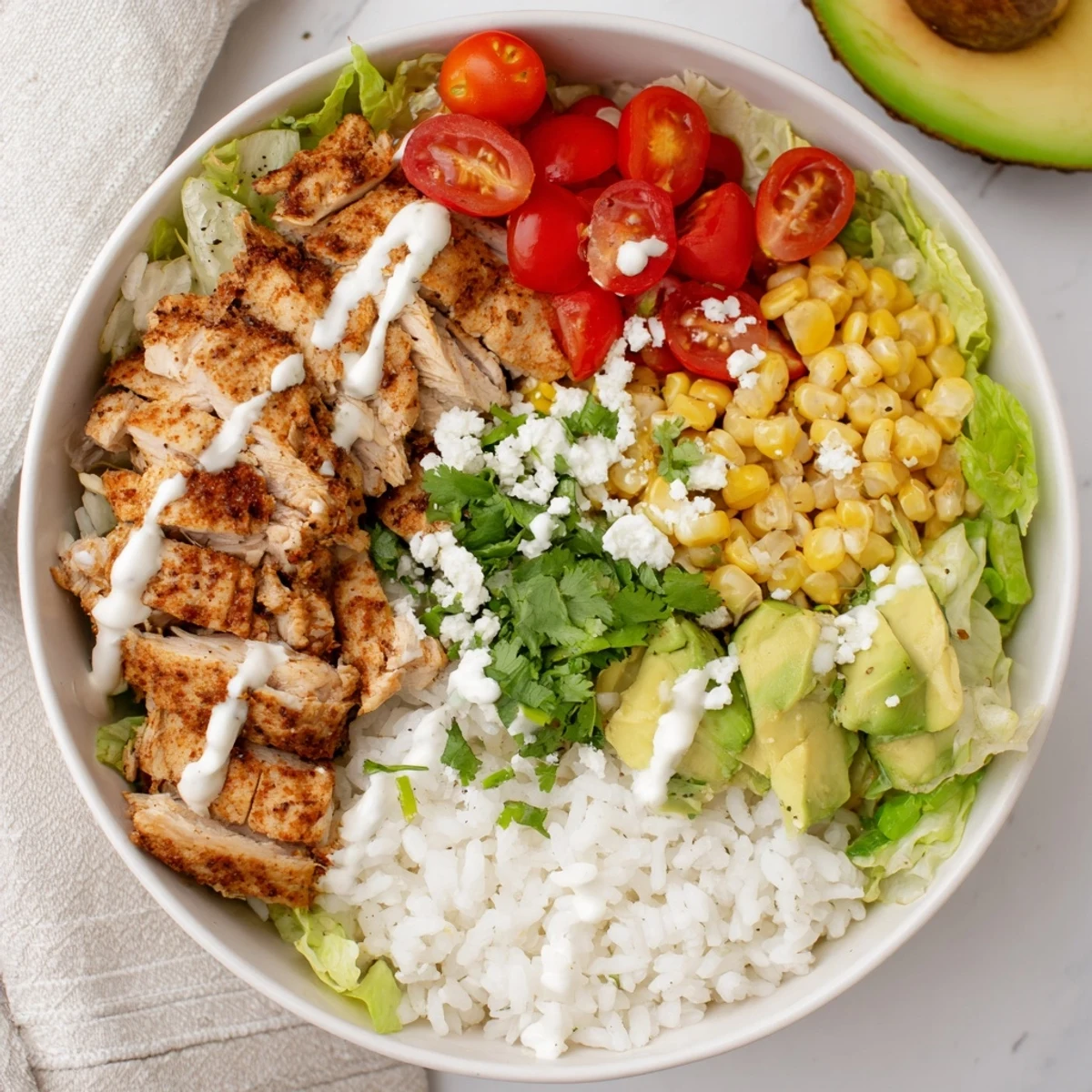 Hearty tasty street corn chicken bowl layered with spiced grilled chicken, buttery roasted corn, ripe avocado, tangy cotija, and crisp lettuce