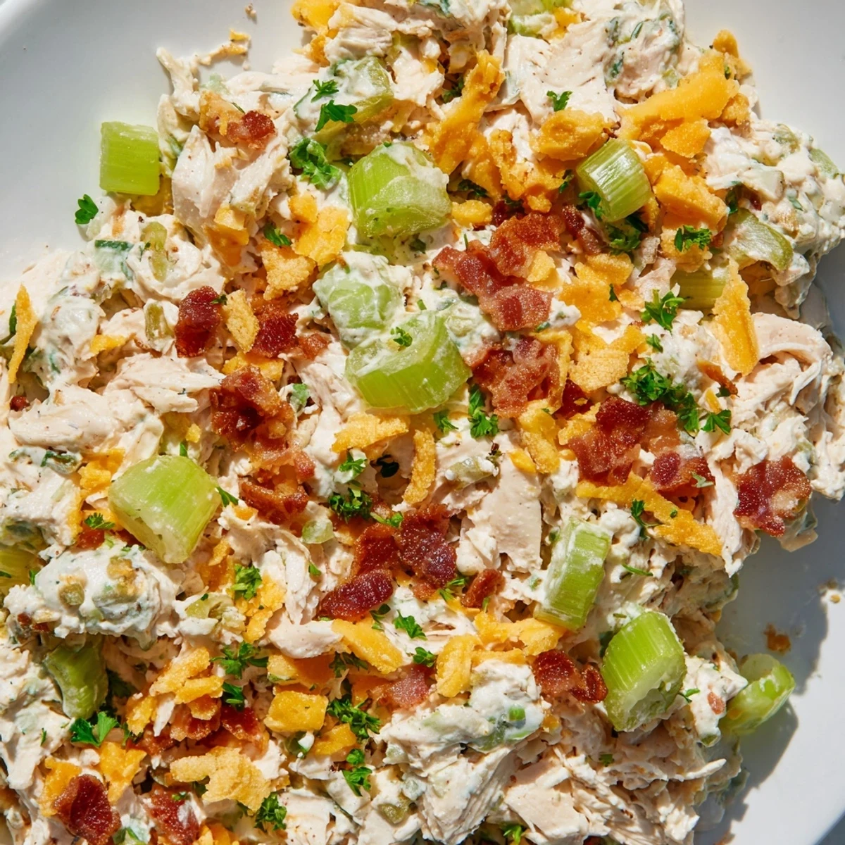 Bowl of zesty cottage cheese chicken salad featuring shredded chicken, melted cheddar, and spicy peppers for a protein-packed meal