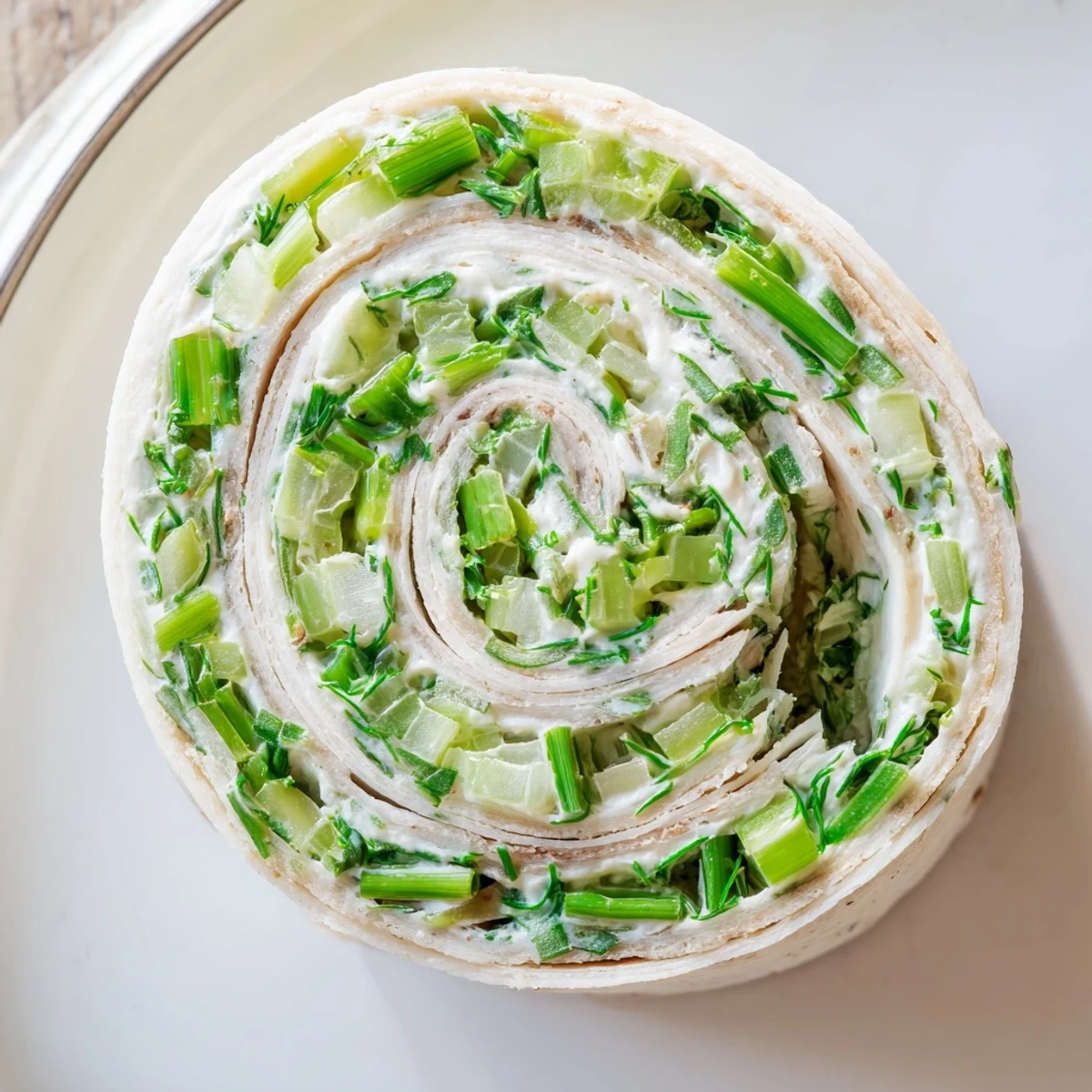 Tangy pickle cream cheese pinwheel appetizers sliced and arranged on serving platter