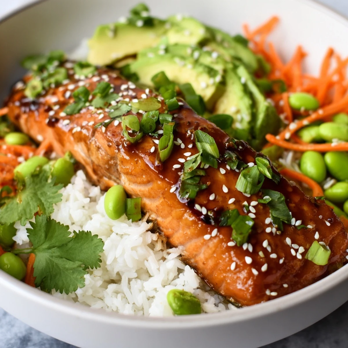 Healthy honey glazed salmon bowl featuring tender fish with avocado and edamame
