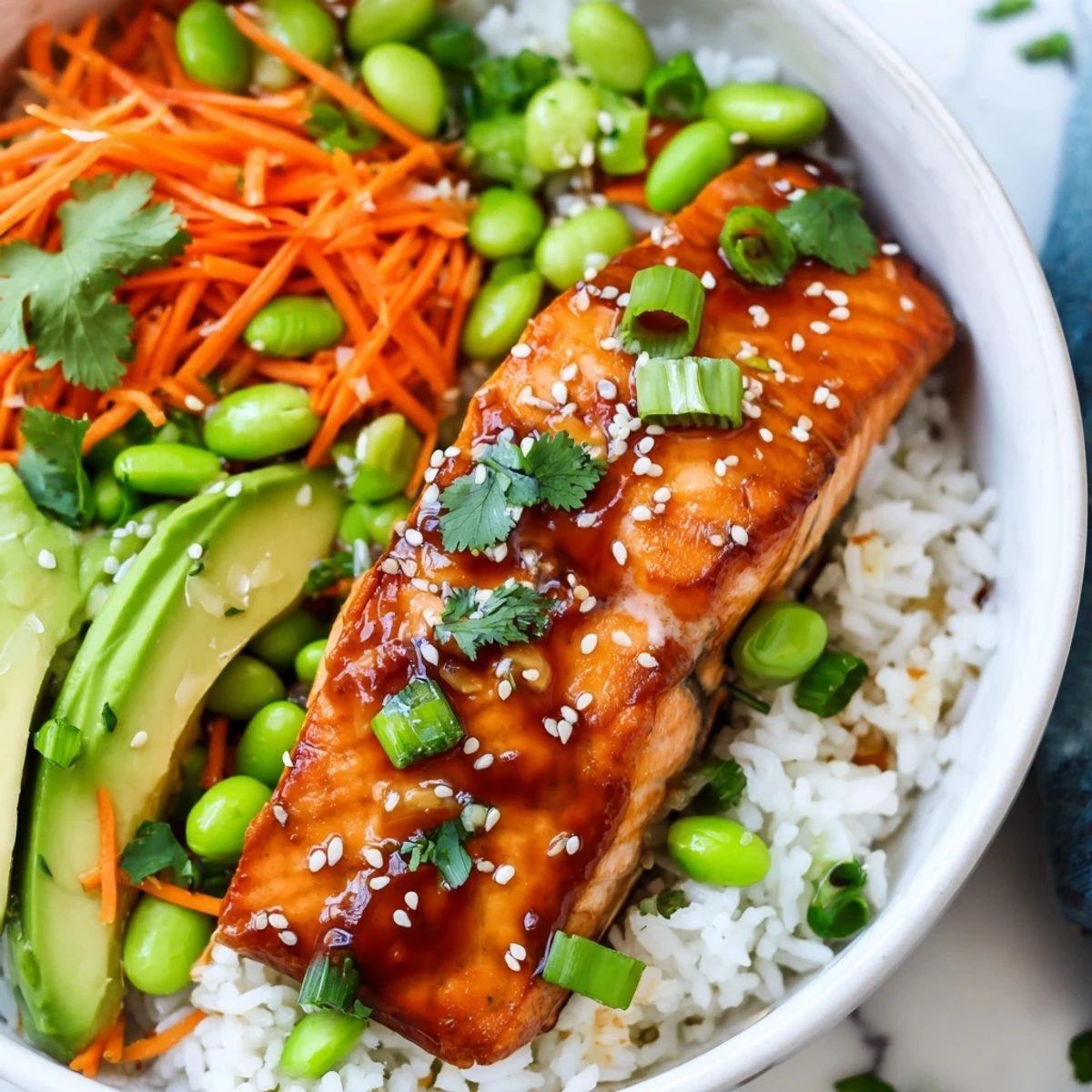Vibrant honey glazed salmon bowl drizzled with sticky glaze over rice and crisp veggies