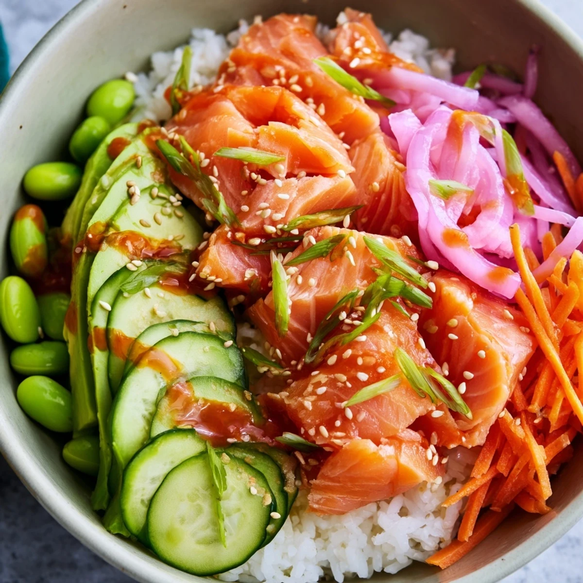 Vibrant easy salmon bowl arranged with colorful vegetables, creamy avocado slices, and zesty spicy mayo topping