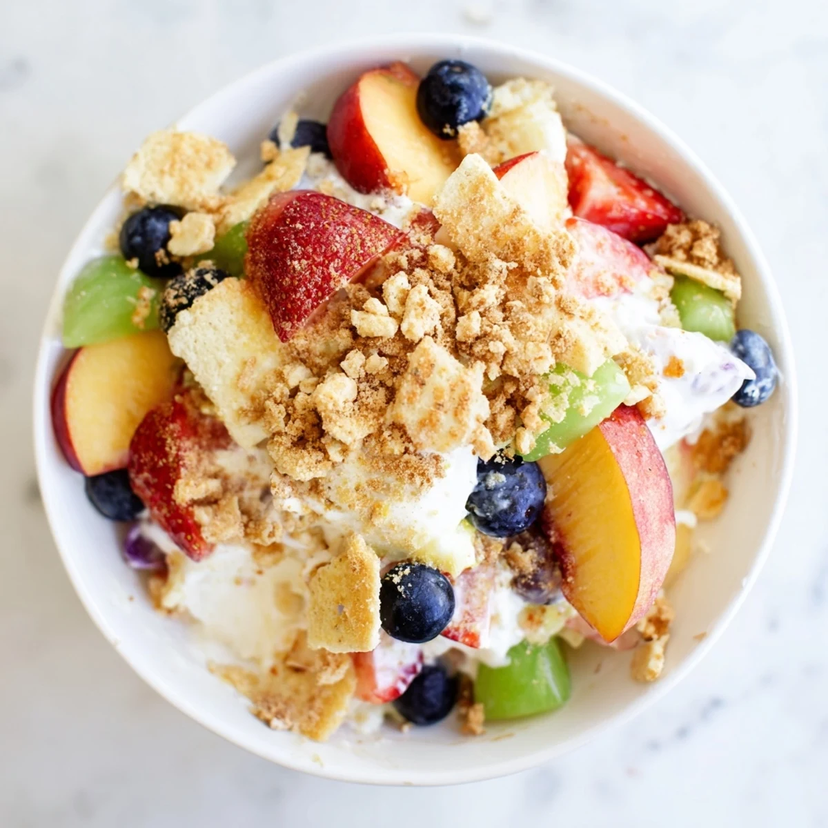 Vibrant summer peach cobbler cheesecake salad featuring juicy peaches, strawberries, blueberries, and sweet vanilla wafer topping