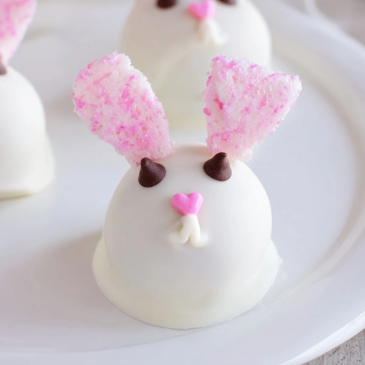 No-bake Bunny Oreo Balls featuring crushed cookie centers dipped in creamy white coating with bunny ears