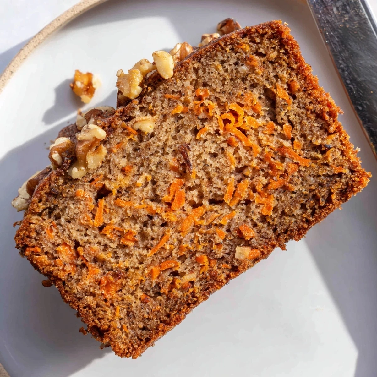 Golden brown spiced carrot cake banana bread slices revealing tender texture with grated carrots and warm cinnamon aroma