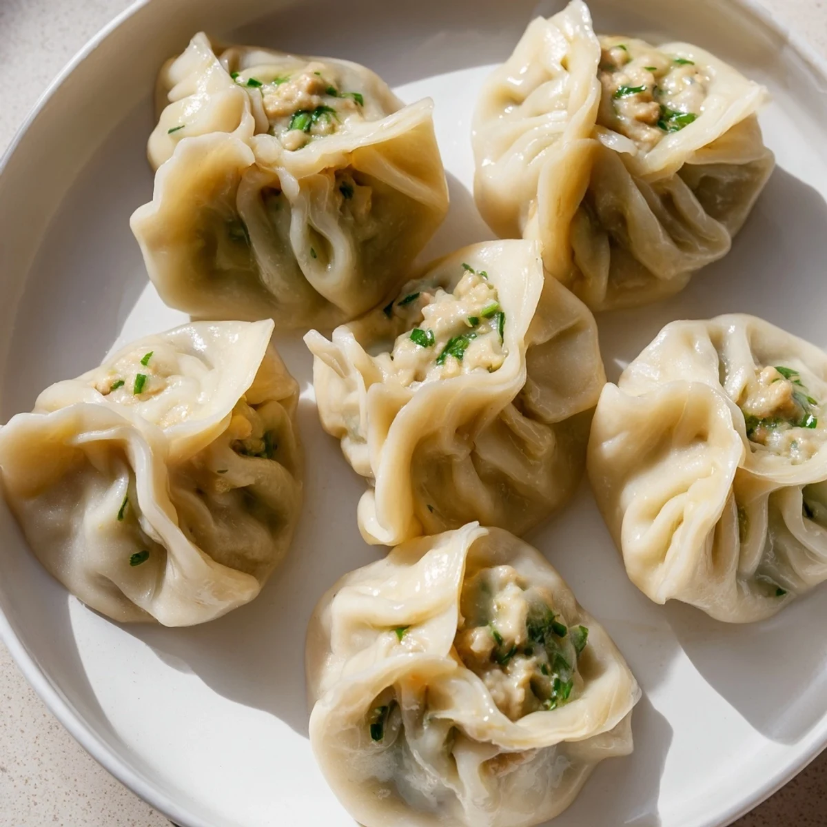 Steaming hot Nepali momo dumplings arranged on a bamboo steamer with spicy tomato dipping sauce