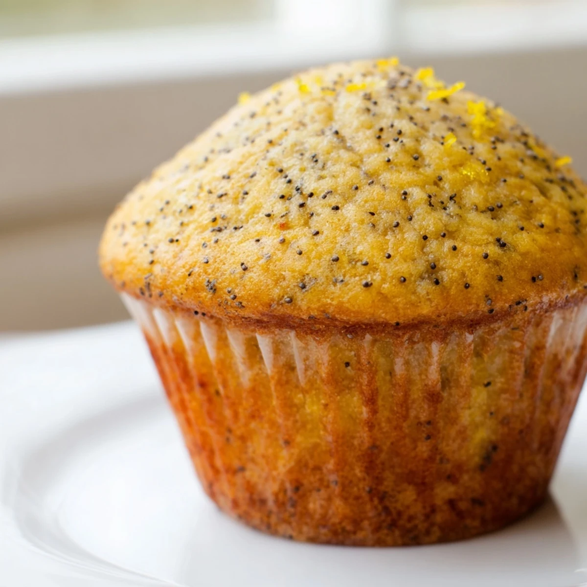 Golden lemon poppy seed muffins with domed tops fresh from the oven