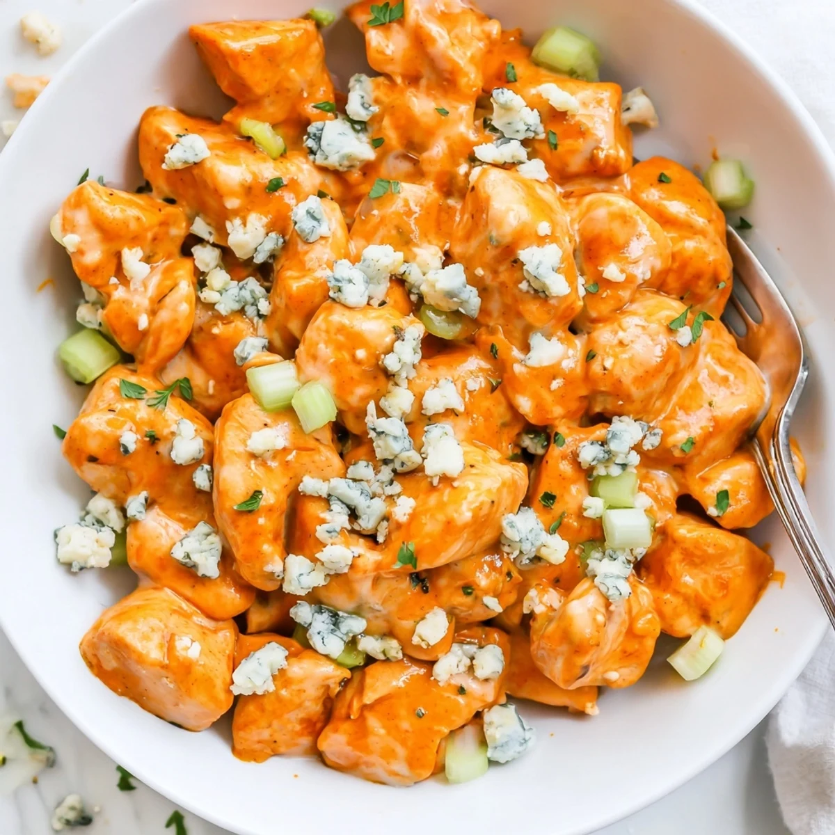 Creamy Keto Buffalo Chicken Skillet topped with crumbled blue cheese and parsley.