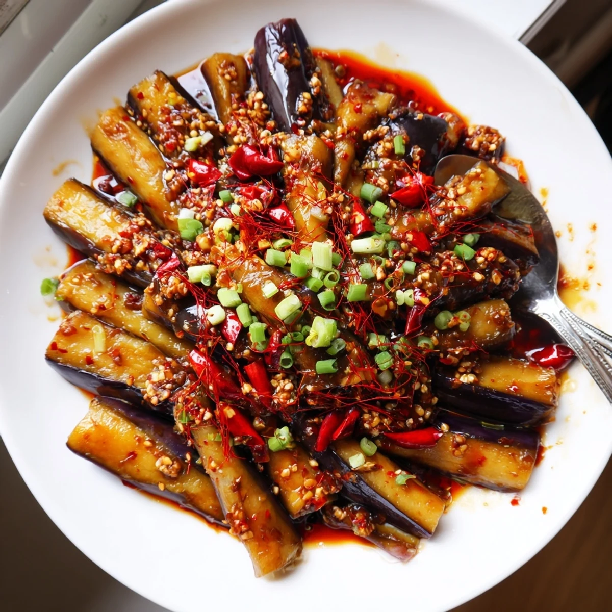 Sichuan Style Braised Aubergines glistening in spicy red sauce over rice