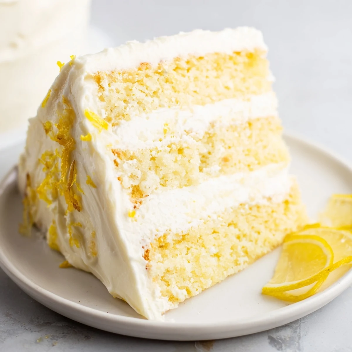 Triple-layer lemon birthday cake topped with tangy cream cheese frosting and edible flower decorations