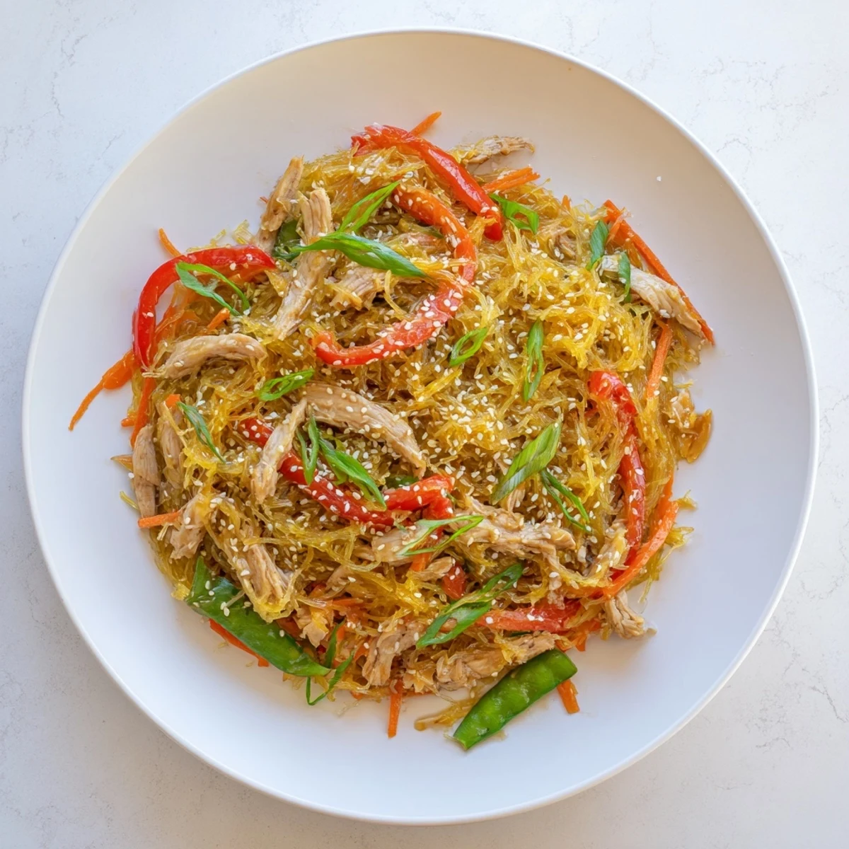 Gluten-free chicken chow mein featuring tender spaghetti squash noodles with crisp bell peppers snap peas carrots