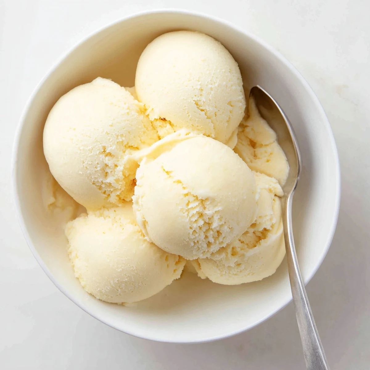 Rich vanilla ice cream recipe swirling in an ice cream maker with soft creamy texture