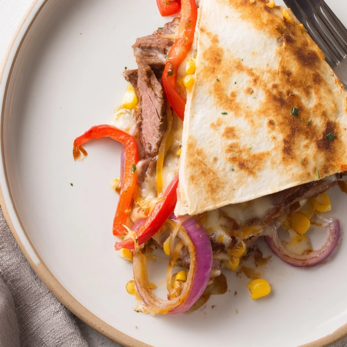 Sweet Savory Beef Quesadillas Recipe sliced into wedges, steaming beef, bright lime wedges
