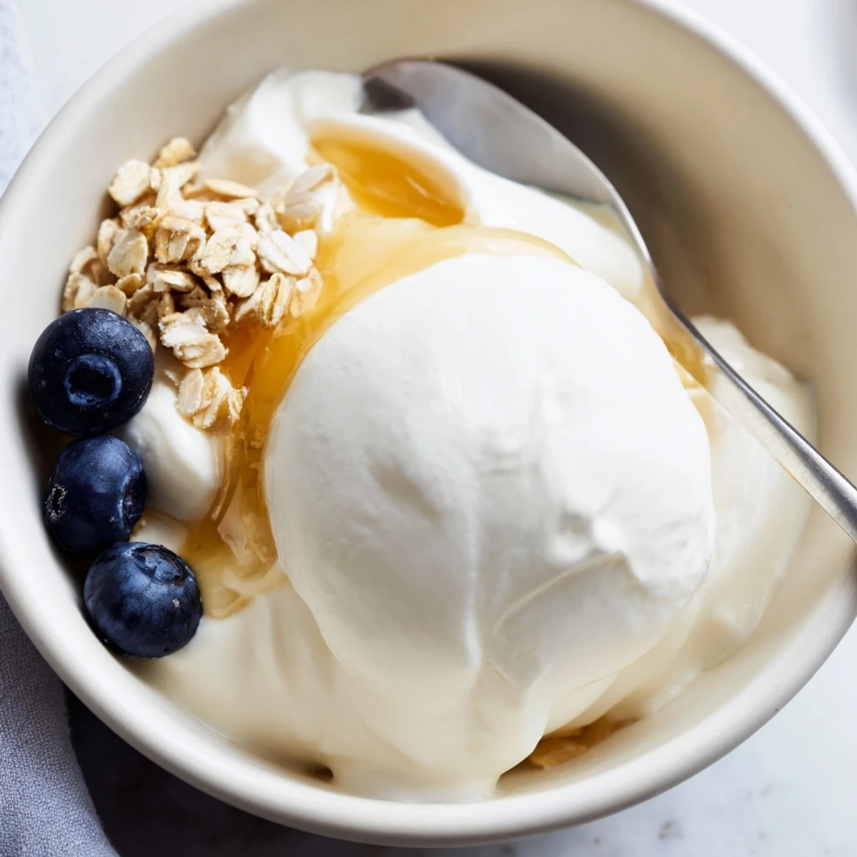 Thick tangy homemade yogurt drizzled with golden honey and crunchy granola