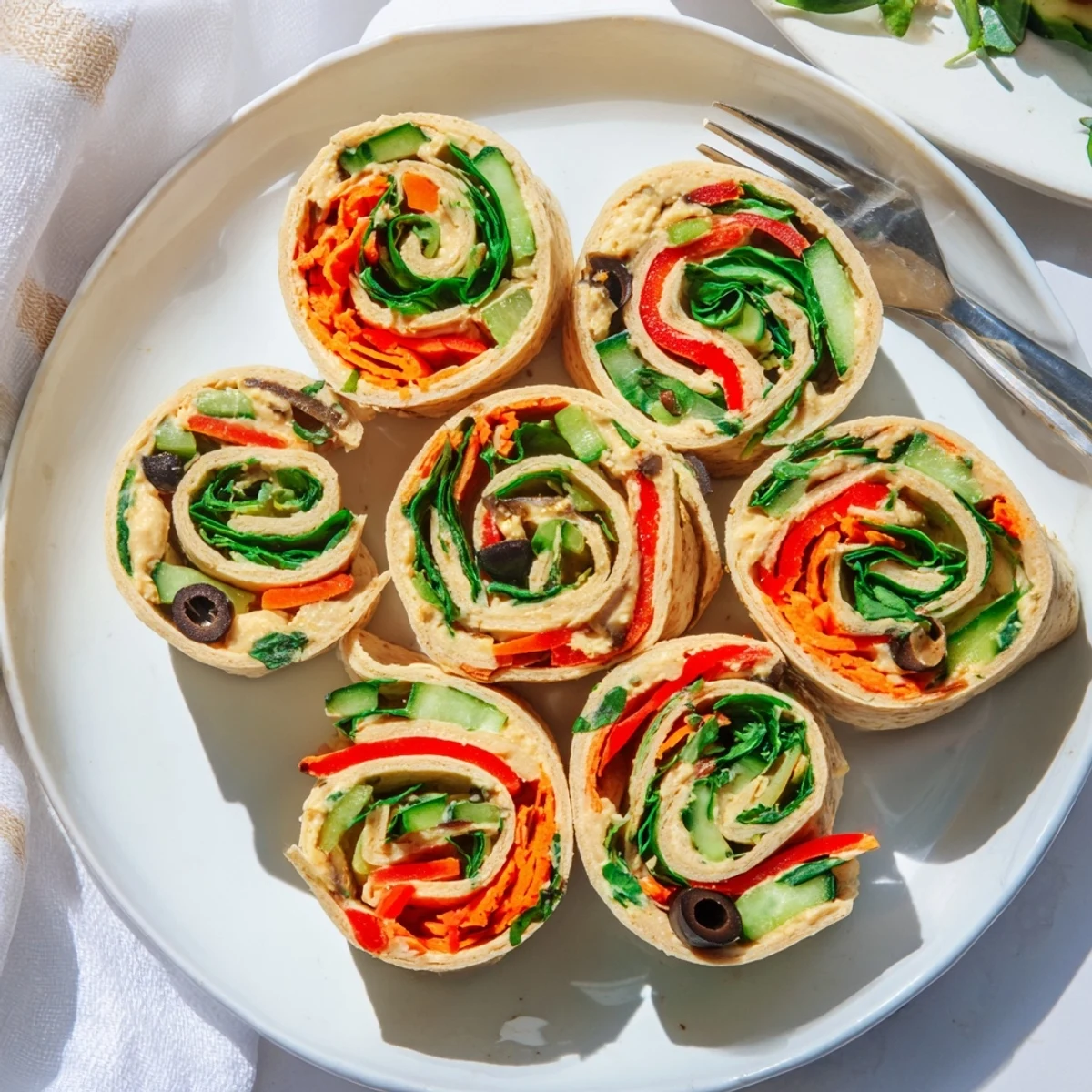 Creamy hummus and crisp vegetables rolled inside fresh vegan picnic pinwheels ready to enjoy